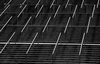 楼梯上带有金属扶手的对称黑白照片创造了抽象图案