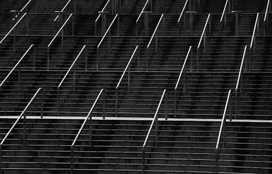 楼梯上带有金属扶手的对称黑白照片创造了抽象图案