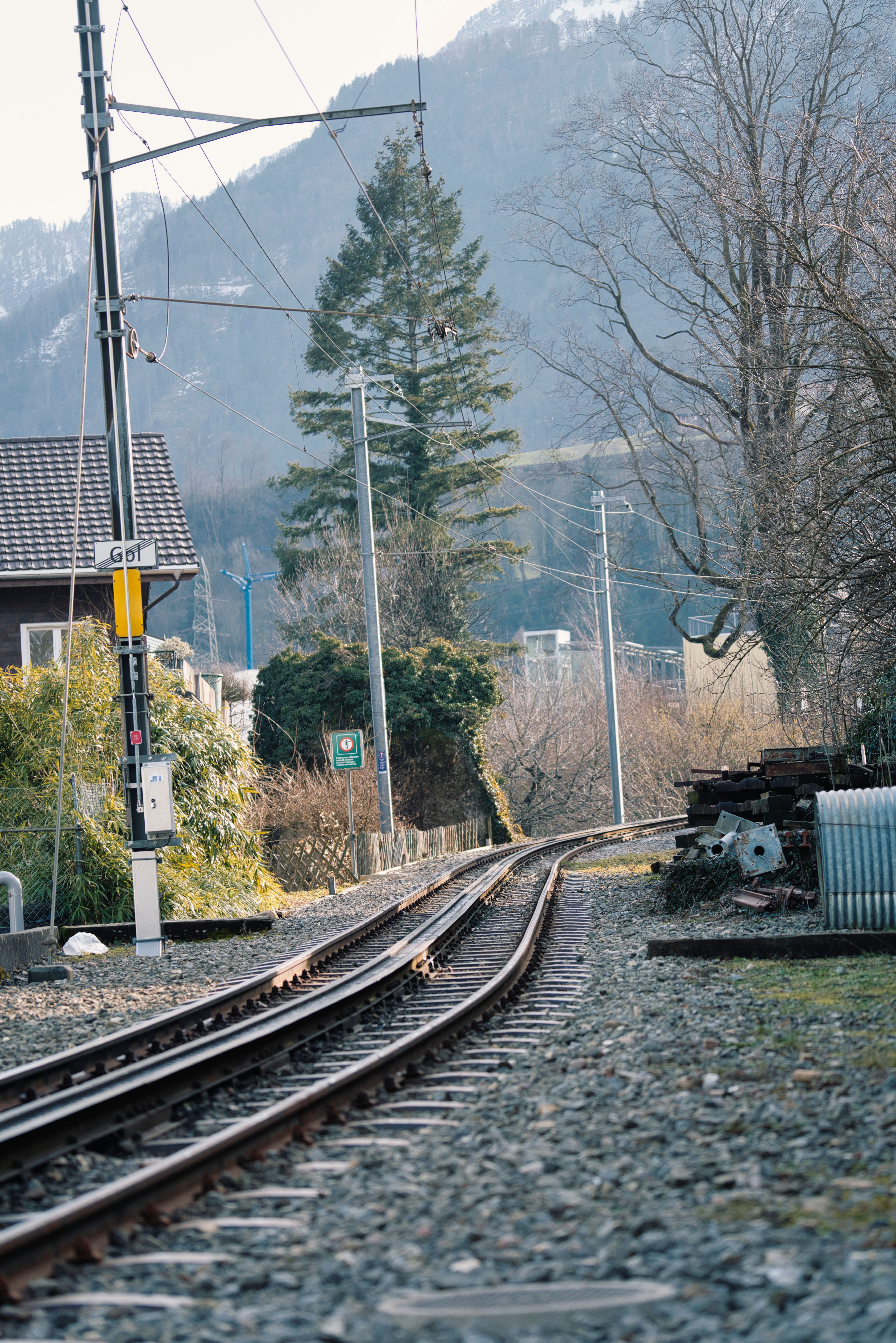 A railway track curves through a mountainous landscape in a serene winter setting.