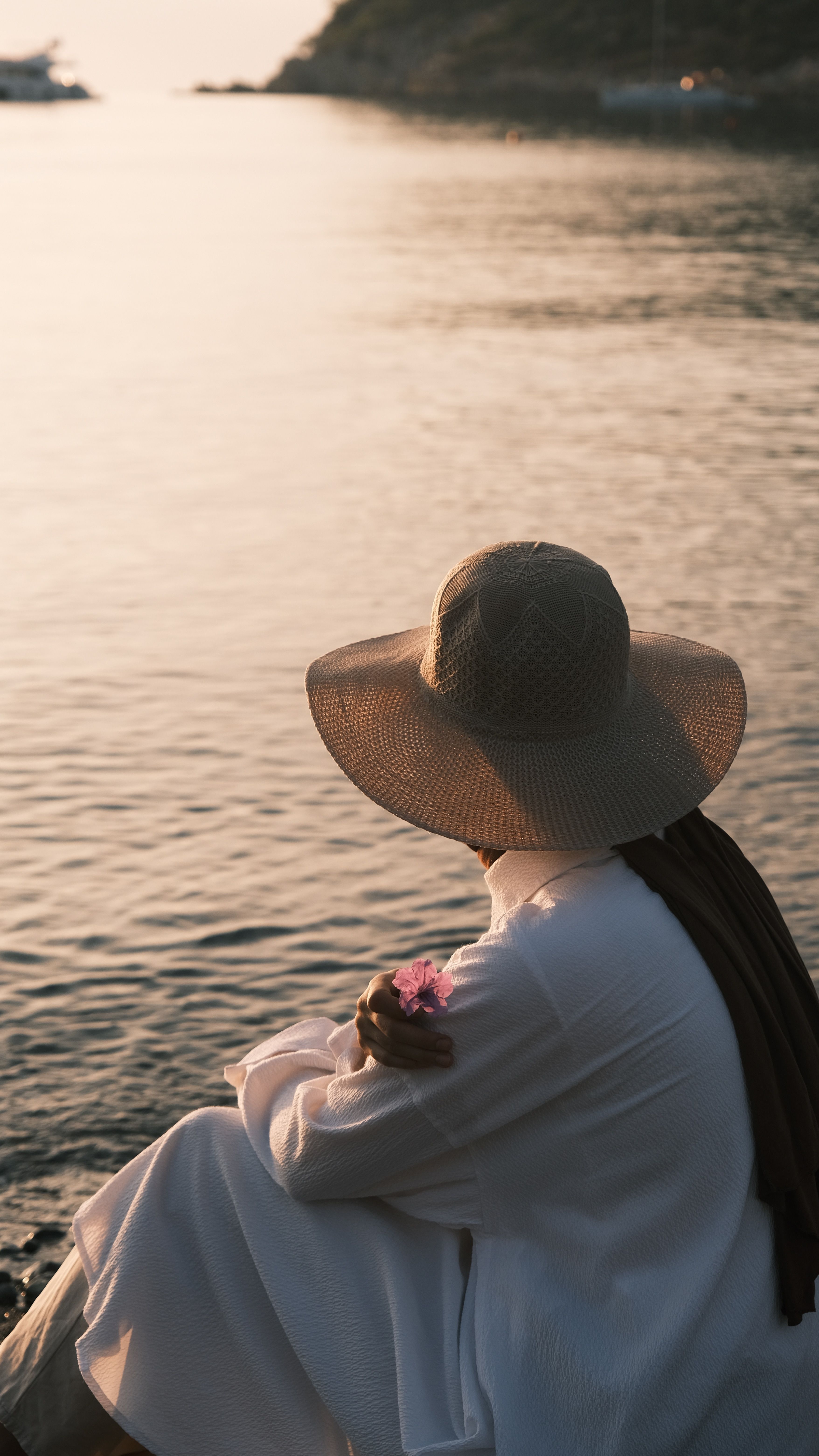 A woman sitting on the edge of a body of water · Free Stock Photo
