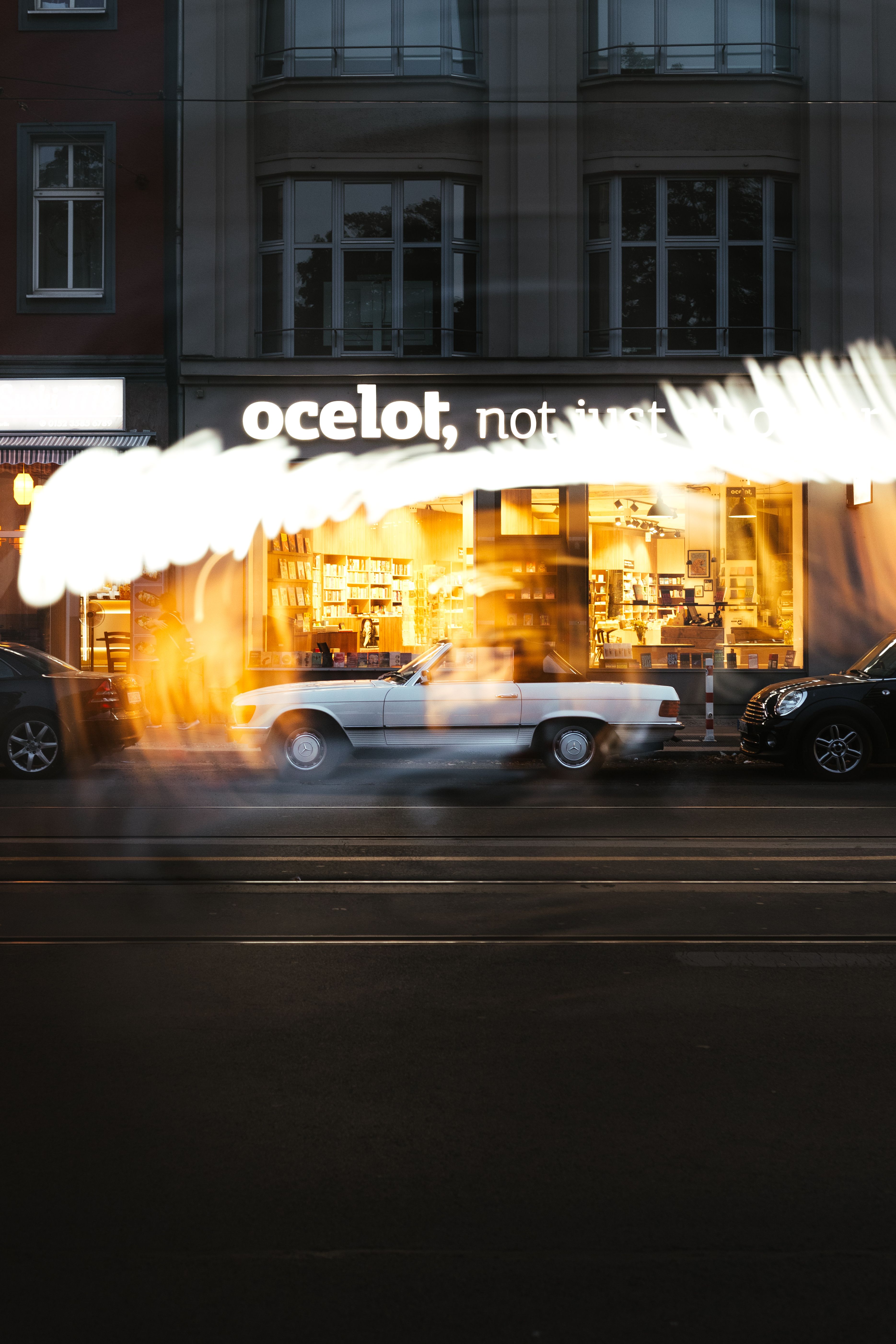 Fotomural Foto de larga exposición de coches pasando por una librería en una calle de Berlín por la noche.