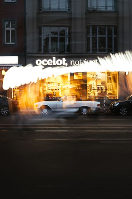 Fotomural Foto de larga exposición de coches pasando por una librería en una calle de Berlín por la noche.