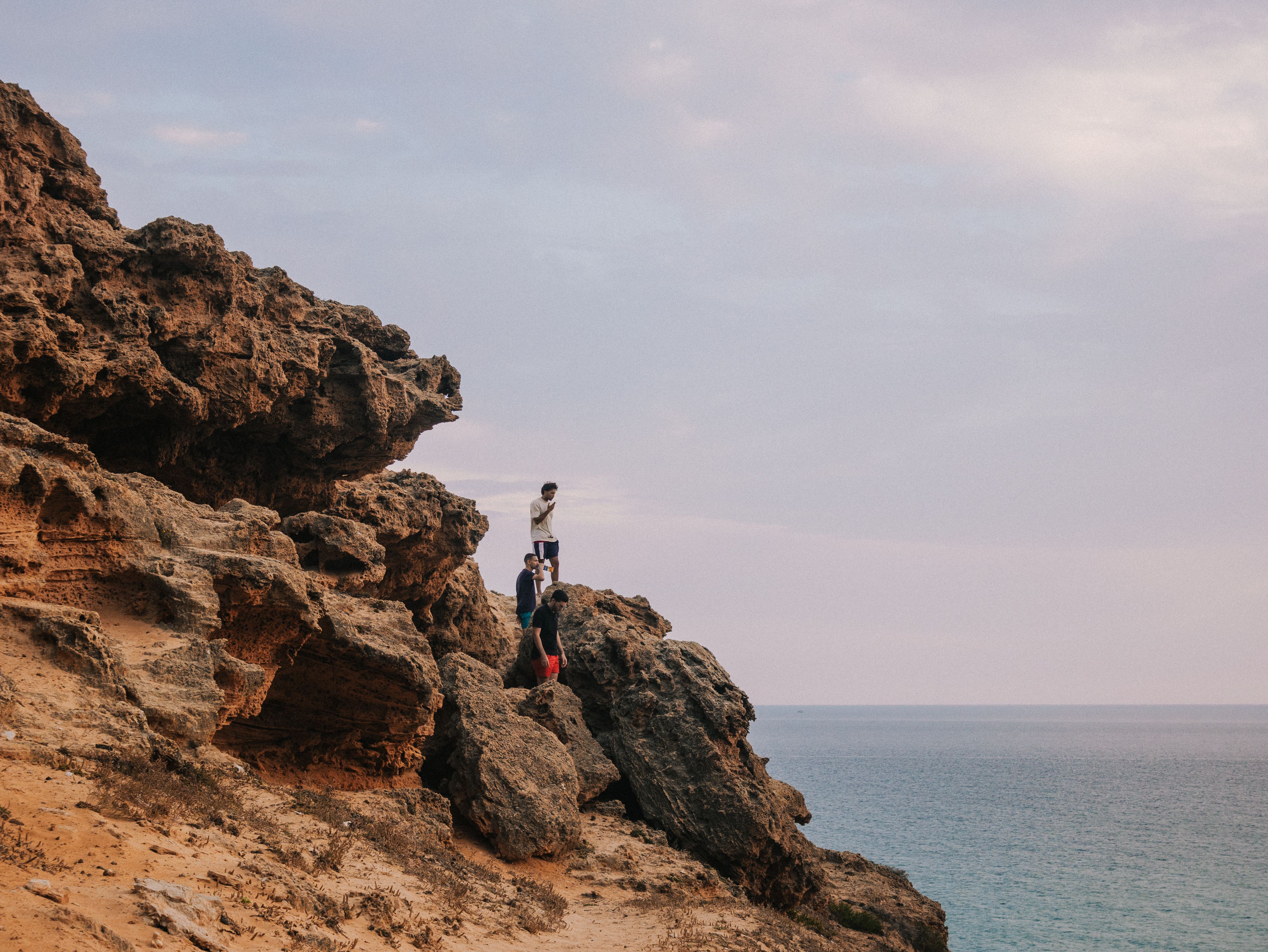 A person standing on the edge of a cliff overlooking the ocean · Free ...