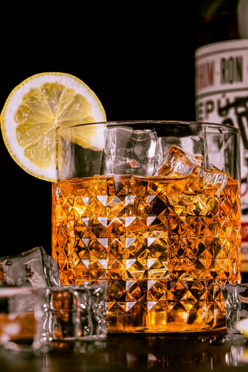 Free Close-up of whisky in a crystal glass with ice cubes and a lemon slice. Stock Photo