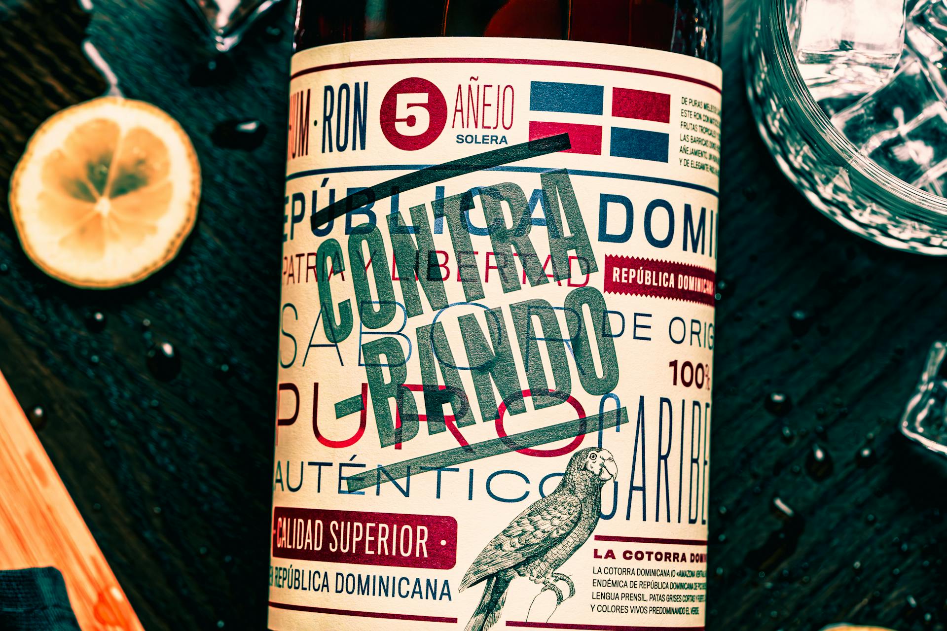 Close-up of a Dominican rum bottle featuring a vibrant Contrabando label with glass and lemon slice.