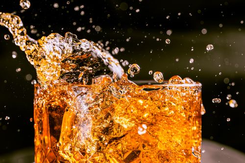 Free Close-up of whiskey splashing in a glass, capturing motion and texture. Stock Photo