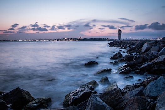 A serene seascape of a lighthouse at dusk on the rocky coastline of İstanbul, Turkey.
