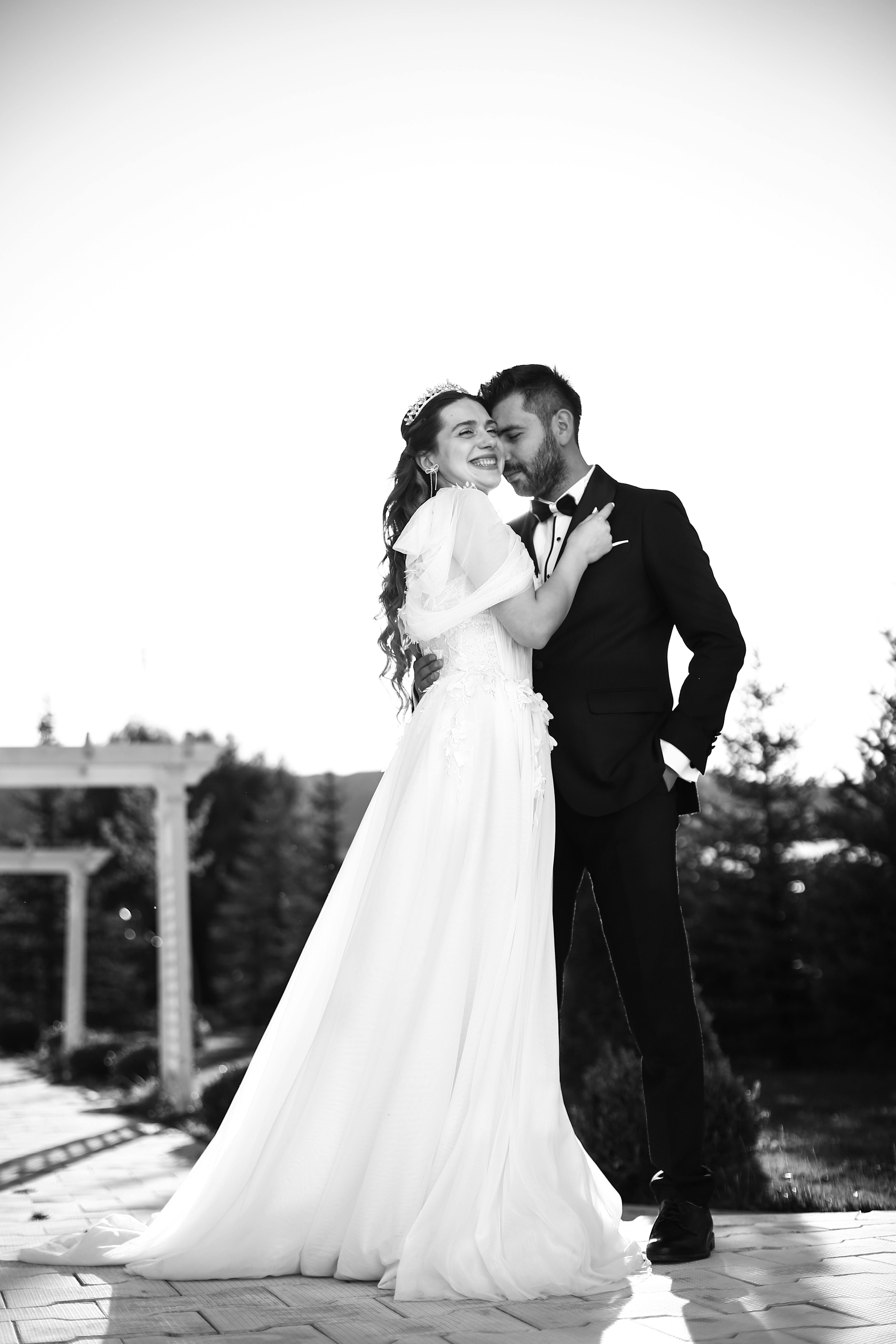 a bride and groom pose for a black and white photo