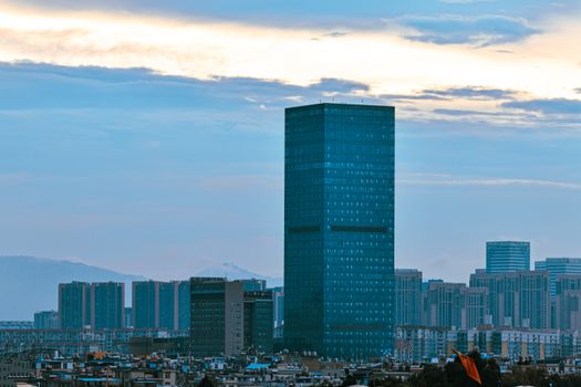A dynamic city skyline featuring high-rise buildings and skyscrapers during twilight hours.