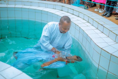Free A baptism ceremony conducted by a man in a pool, symbolizing spiritual renewal. Stock Photo