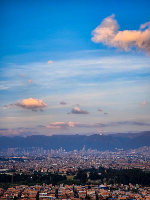 Free Dynamic cityscape of Bogotá with mountains and vibrant blue sky showcasing urban and natural beauty. Stock Photo
