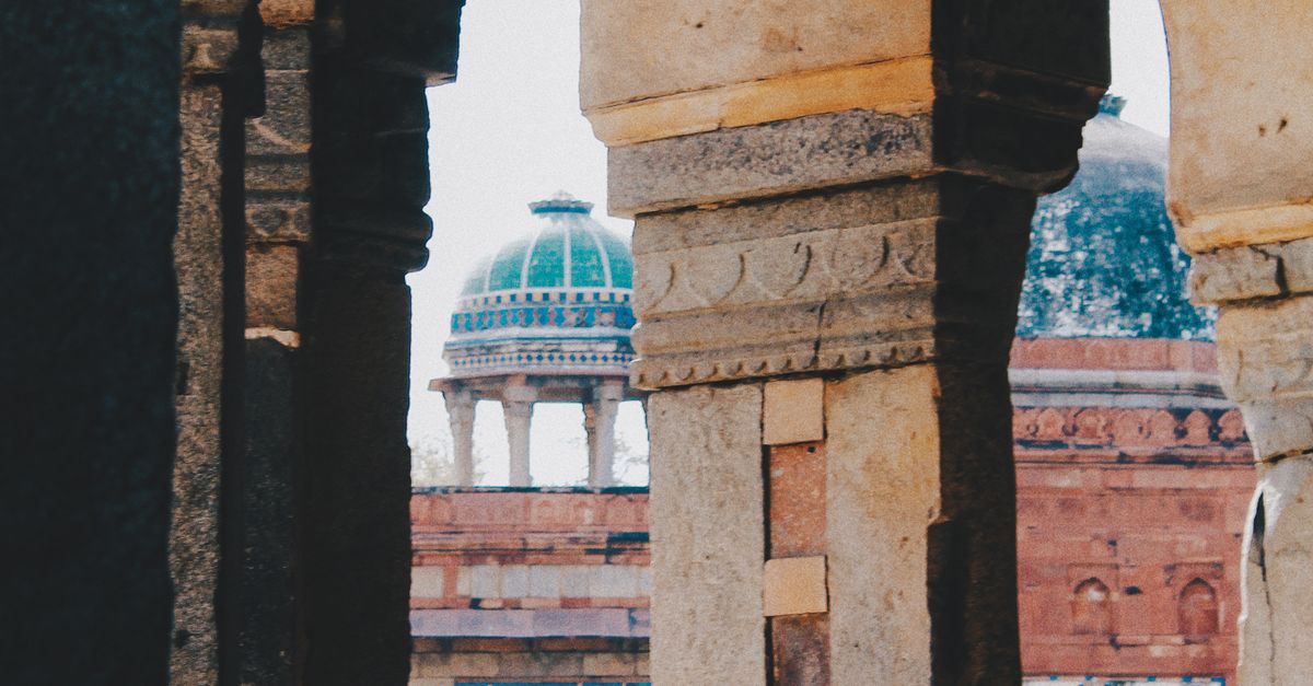 Intricate gothic arches amidst ancient Indian architecture, showcasing historical depth and design.