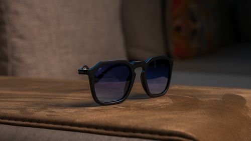 Free Close-up of sunglasses resting on a plush sofa, evoking a relaxed and stylish vibe. Stock Photo