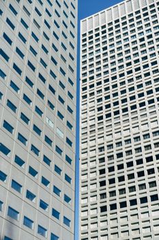 Low angle view of modern skyscrapers with geometric patterns in Tokyo city.