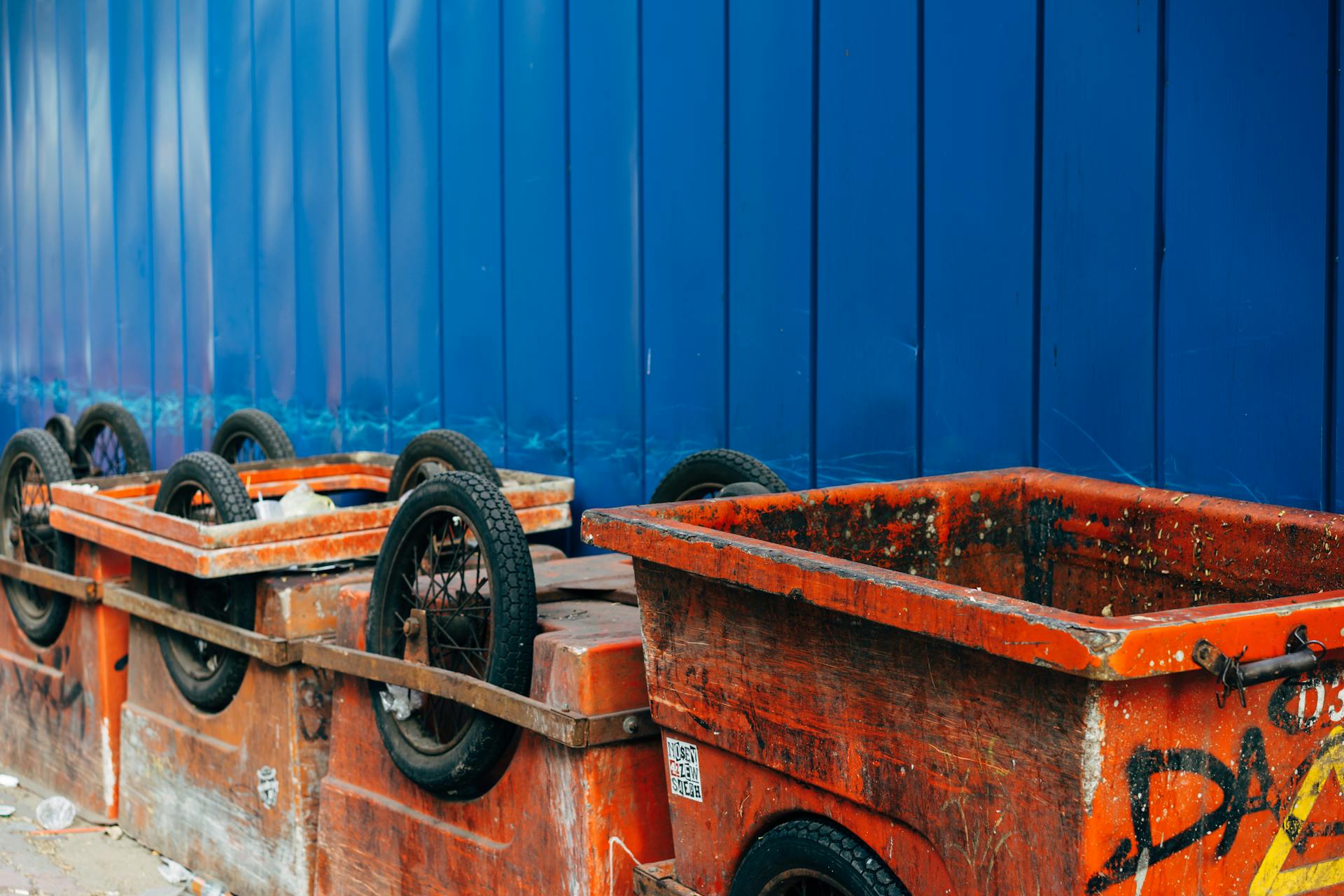 Dirty Containers with Wheels Standing on the Outside of a Building