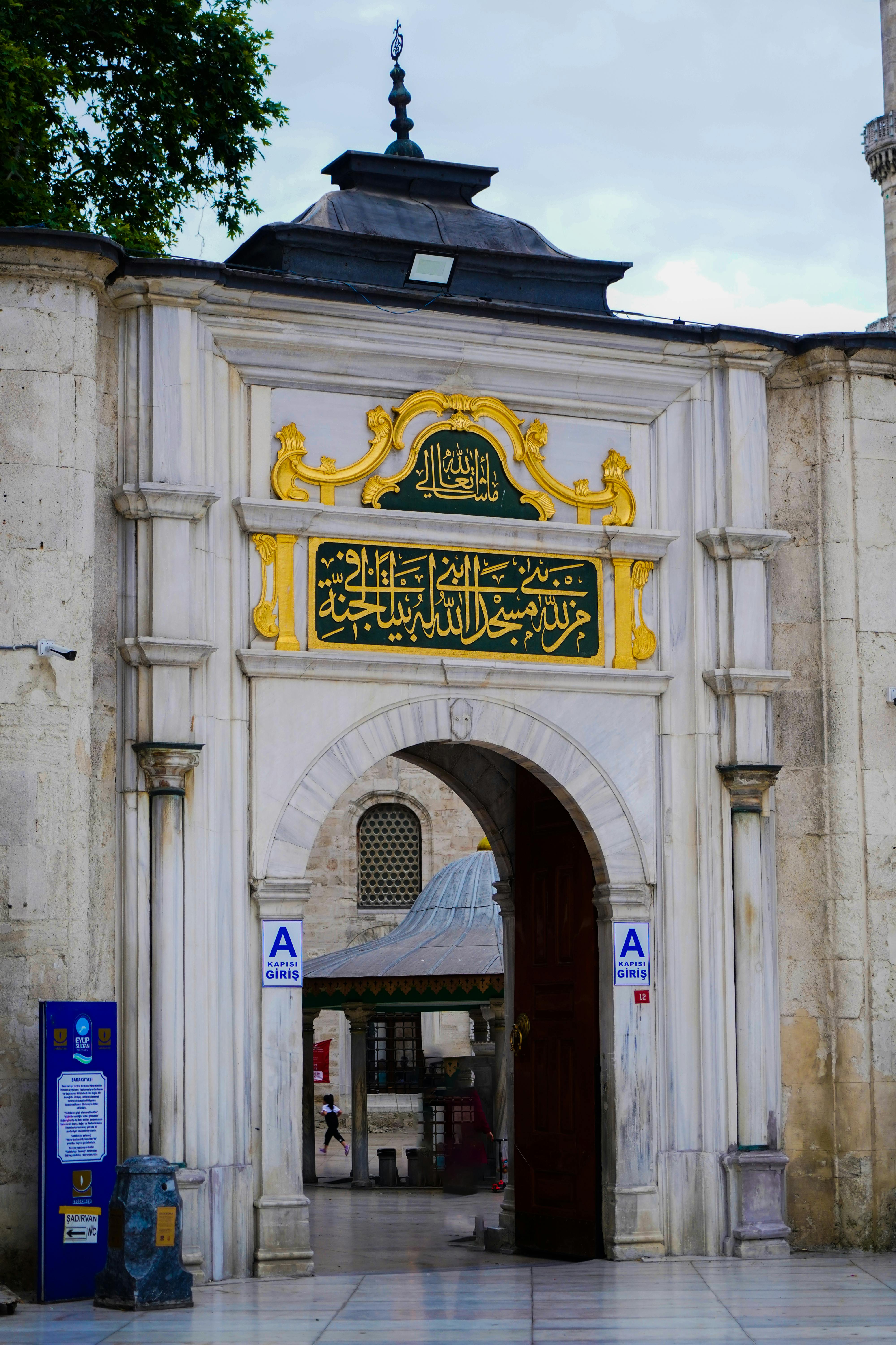 Entrance of Eyüp Sultan Mosque showcasing intricate architecture and religious symbolism.