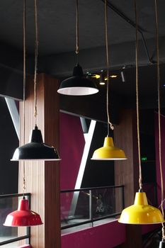 Colorful industrial lamps hanging in a vibrant modern interior space.