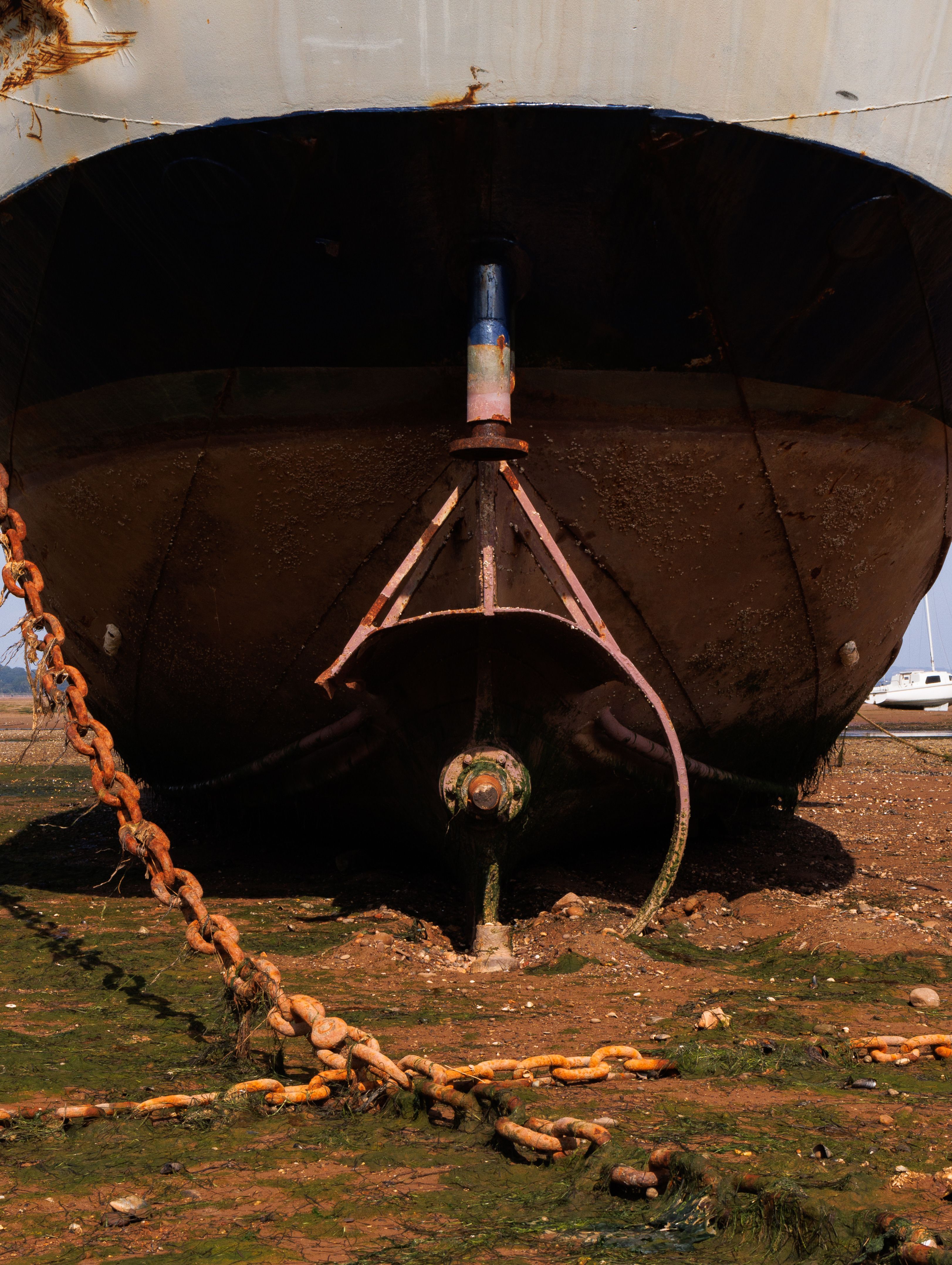 The bow of a ship on blocks in dry dock, anchor chain run out