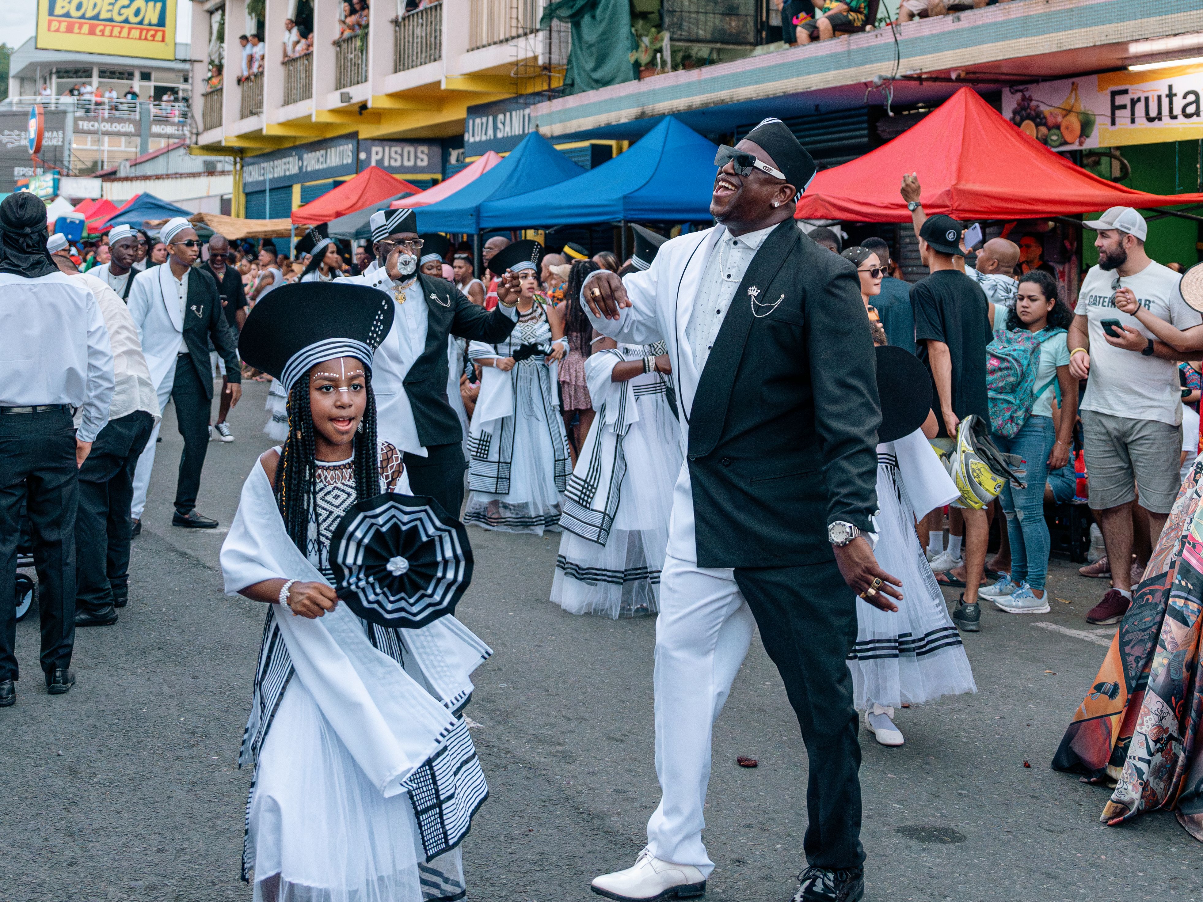 People celebrating in colorful street parade in Limón, Costa Rica, highlighting Afro-Costa Rican culture.