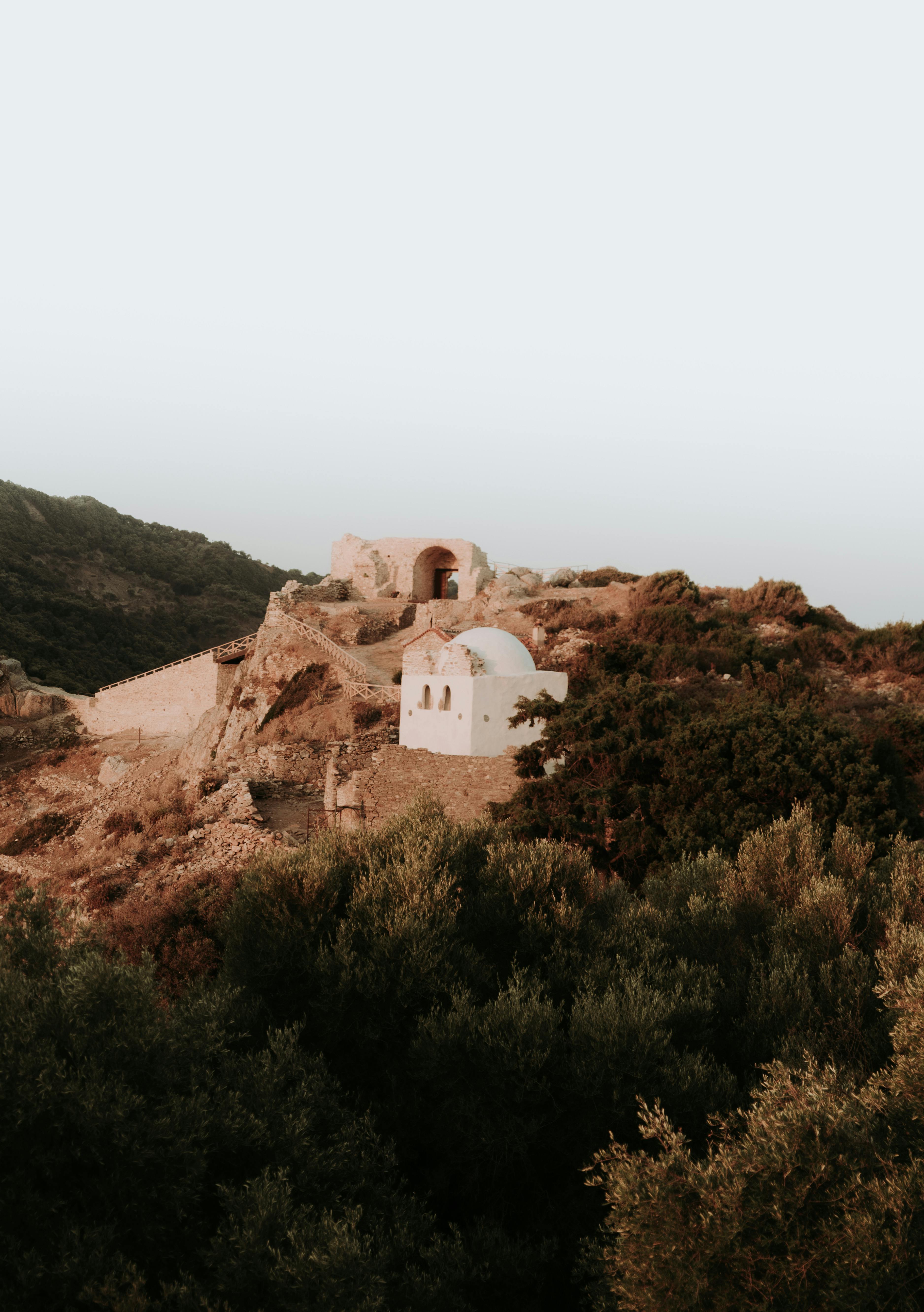 Charming view of historical hillside architecture amidst desert landscape during sunset.