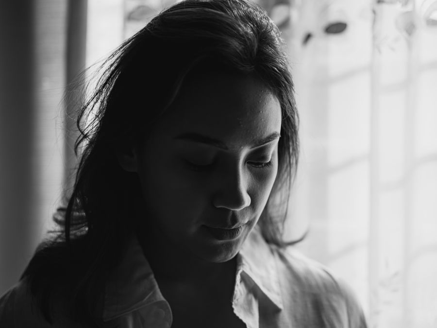 Monochrome portrait of a woman in a pale collared shirt, lit from a window — photo by Tokuo Nobuhiro on Pexels