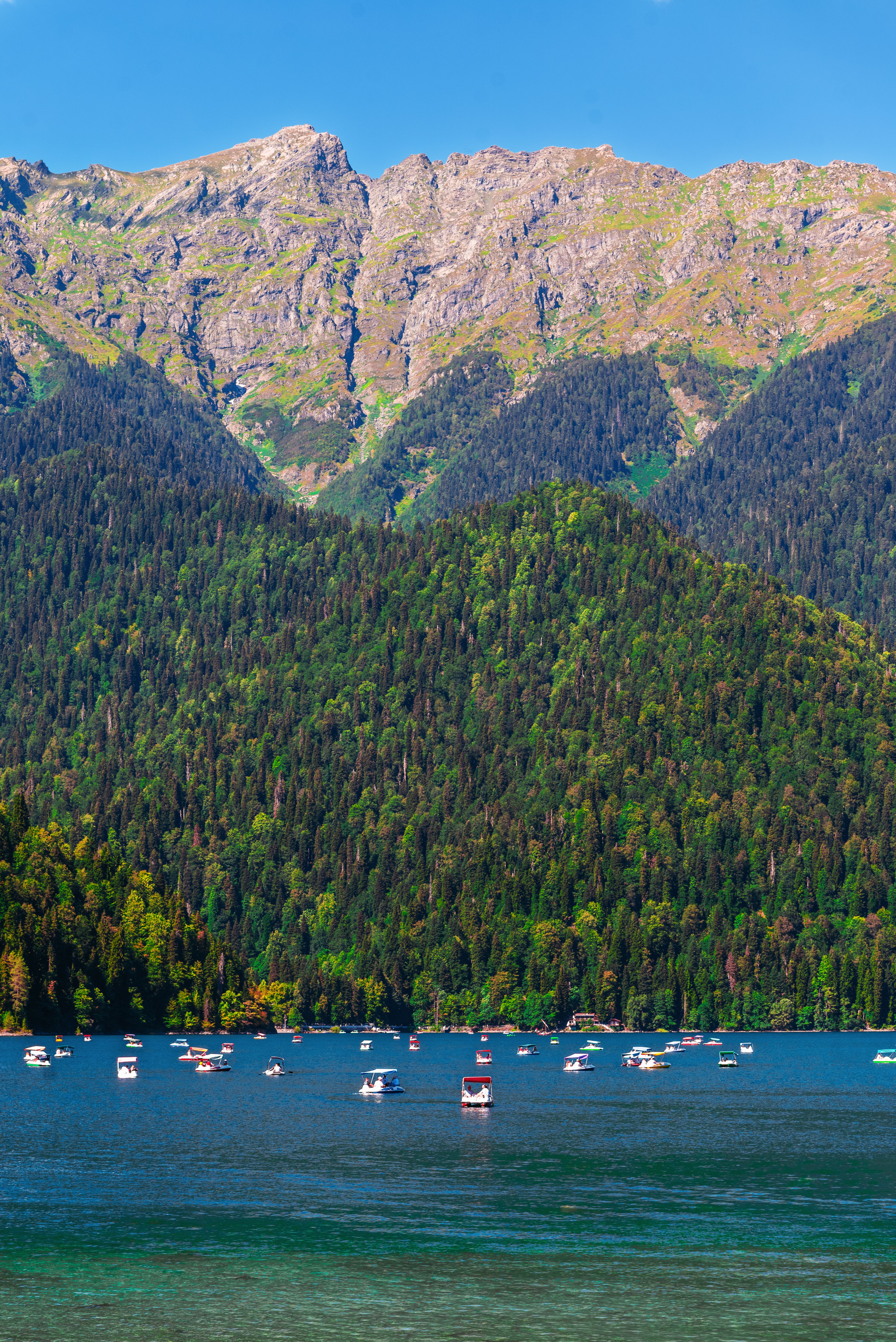 Picturesque view of a tranquil lake surrounded by lush green mountains in Гагра.