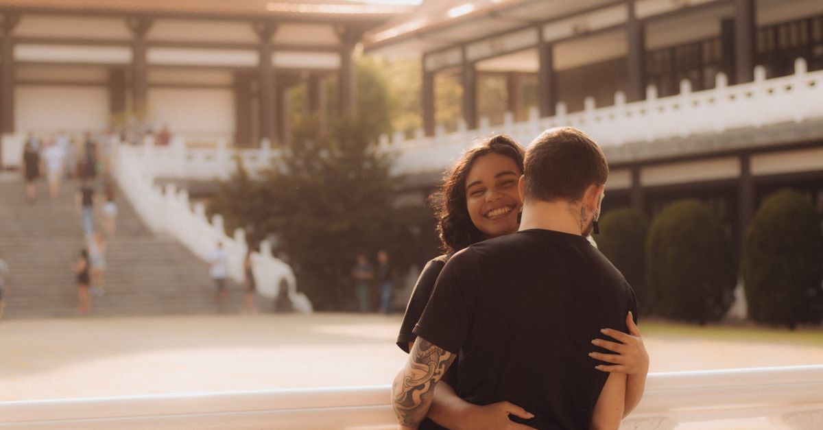 A couple hugging in front of a building · Free Stock Photo