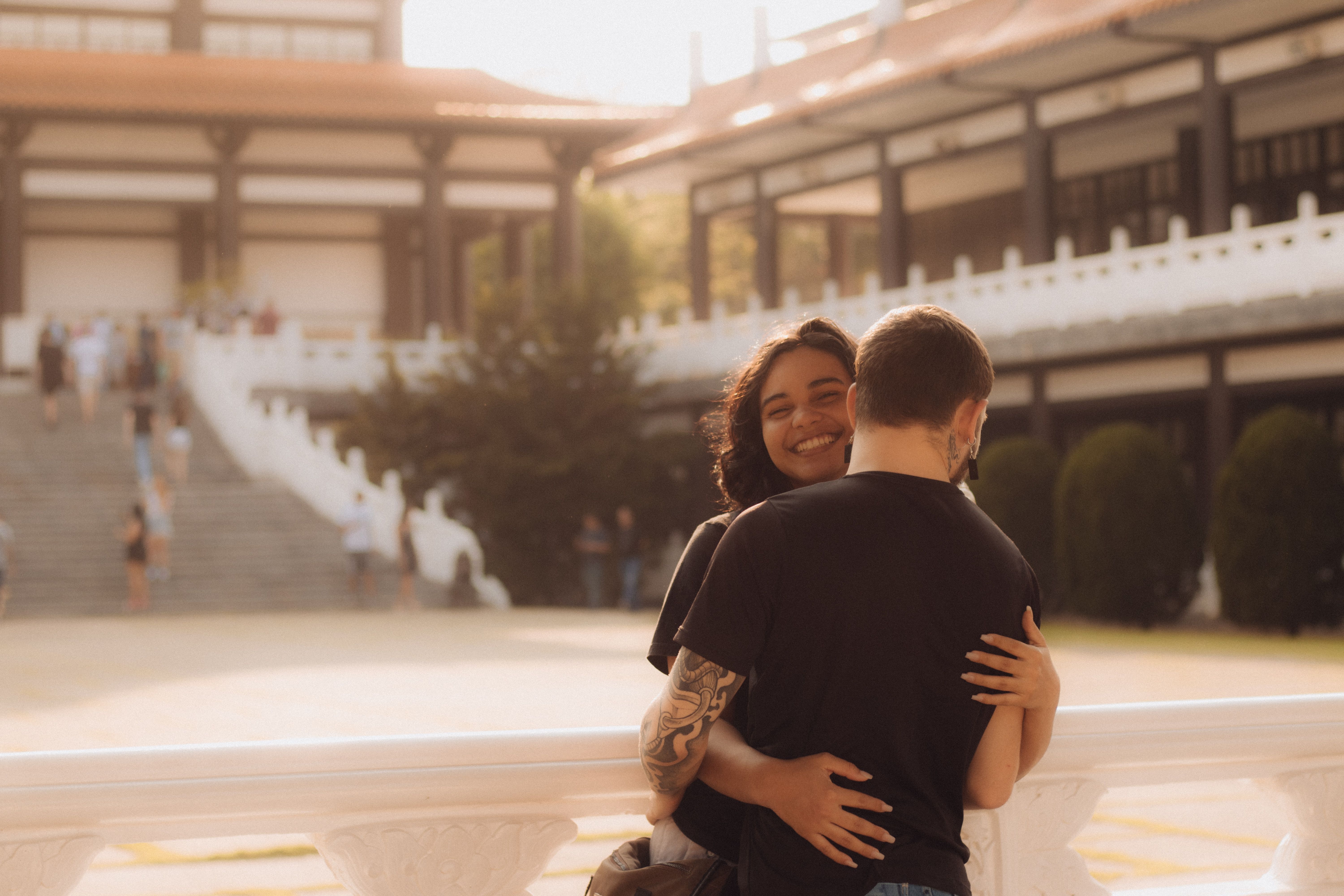 A couple hugging in front of a building · Free Stock Photo