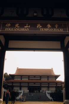 Stunning view of Templo Zu Lai's traditional entrance with visitors exploring the Buddhist architecture.