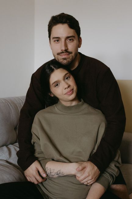 A couple tenderly embracing while sitting on a sofa indoors, showcasing love and connection.