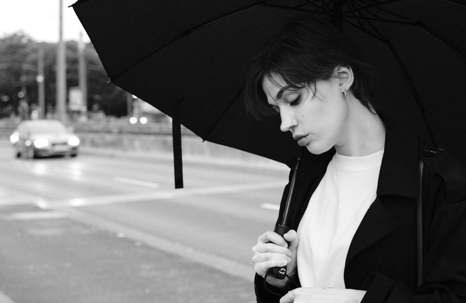 A captivating black and white portrait of a woman with an umbrella on a rainy day in Cologne, Germany.