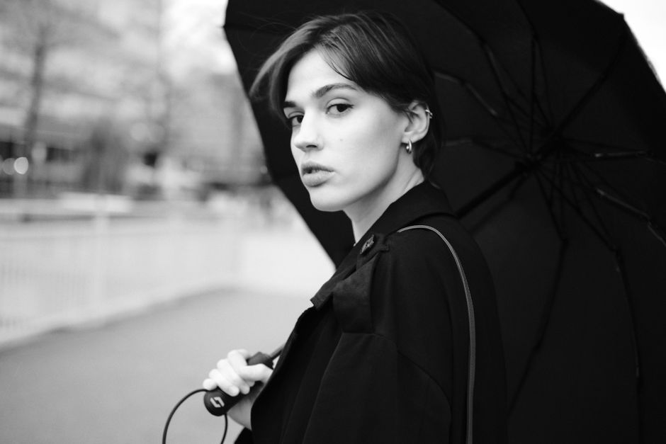 Black and white portrait of an elegant woman with an umbrella in an urban setting, Cologne.