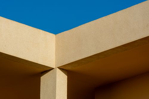 Free Minimalist architectural photo highlighting geometric shapes and shadows against a clear blue sky. Stock Photo