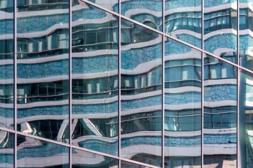 Free Abstract reflections of urban architecture on a modern glass facade capturing a unique visual distortion. Stock Photo