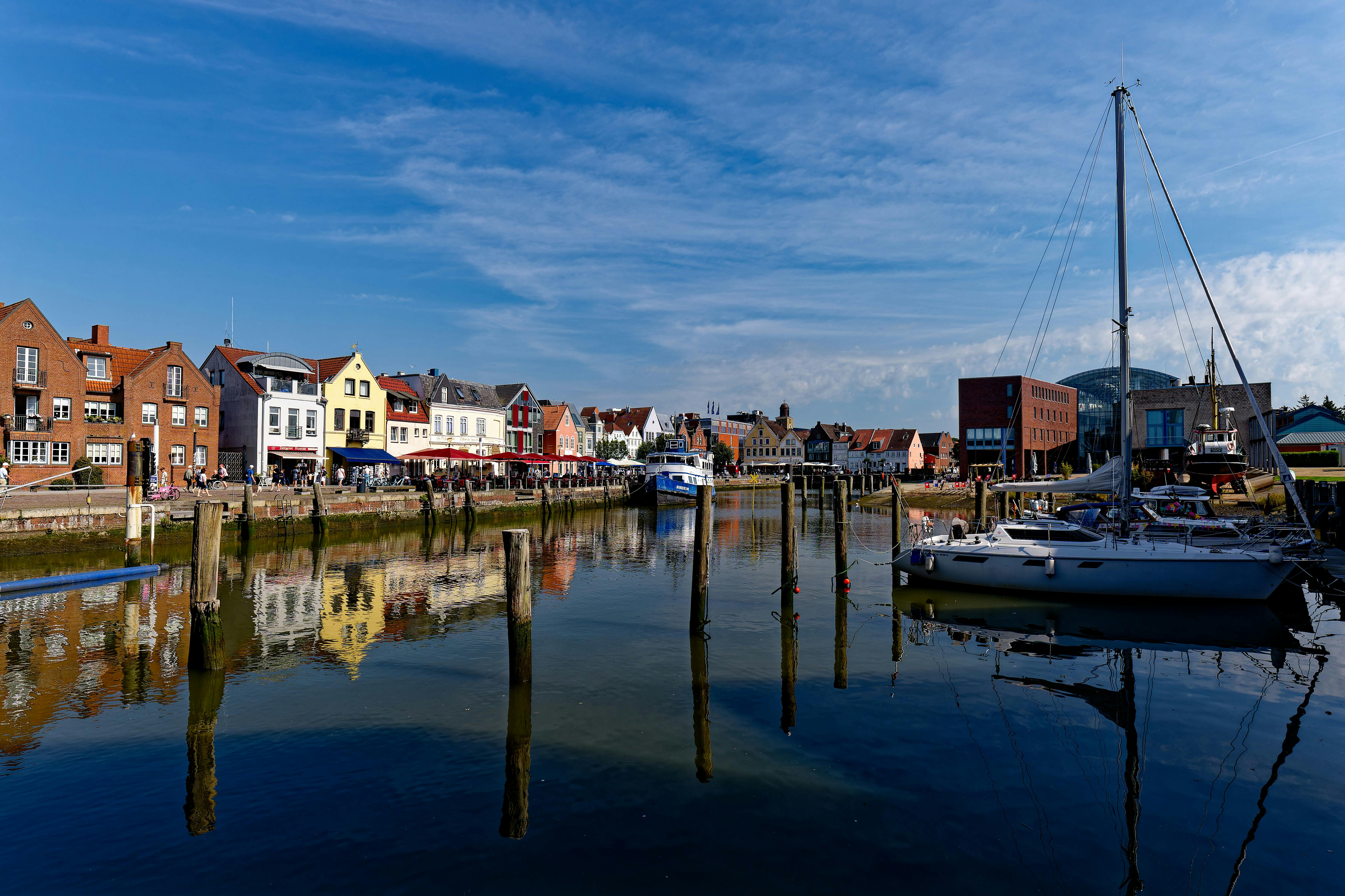 Beautiful view of Husum harbor with reflections of colorful buildings and boats.