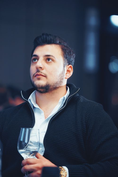 Free A stylish man in business casual attire holding a wine glass indoors in Istanbul. Stock Photo