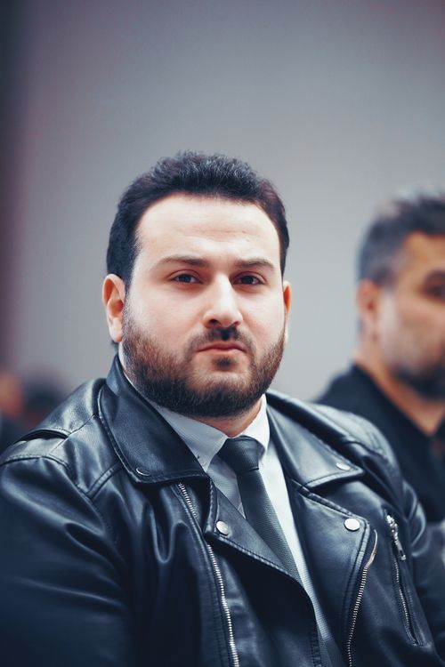 Free Portrait of a man in a leather jacket with a serious expression, captured indoors. Stock Photo