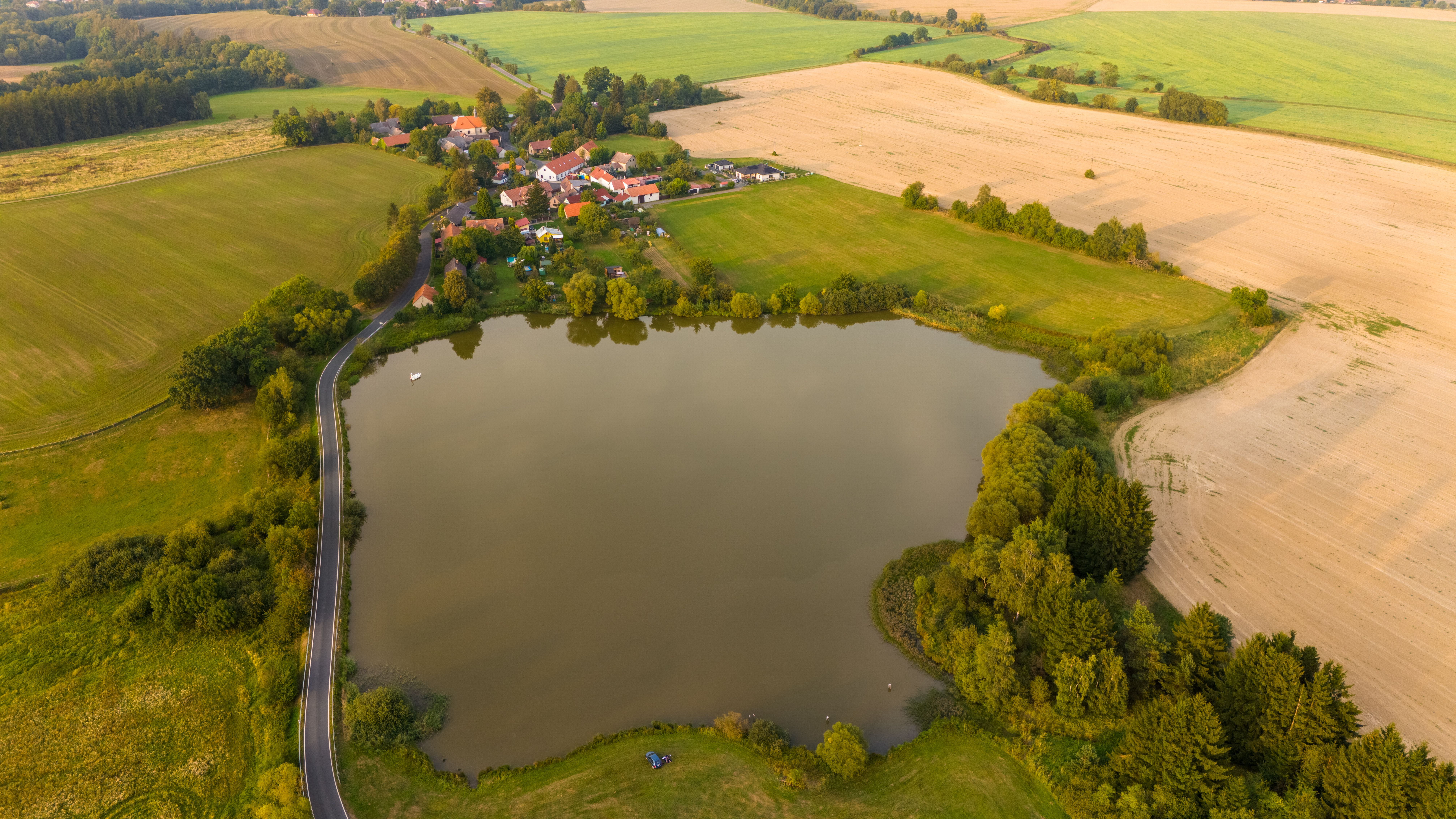 Aerial view of a lake surrounded by farmland · Free Stock Photo