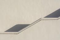 A white wall with a stairway and shadow