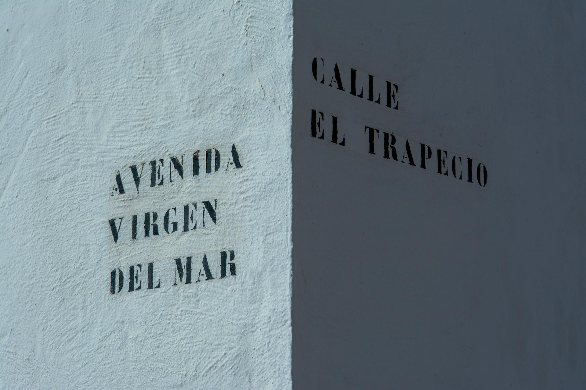 A white sign with the words ave, el viento and the name of the street