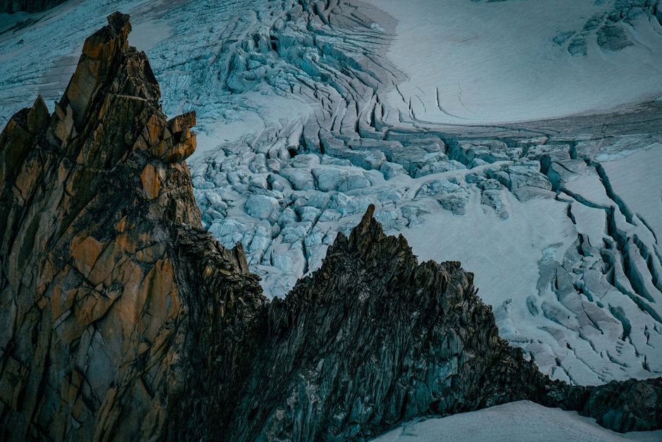 A breathtaking view of snow-capped mountains with rugged rocks and a glacial expanse.
