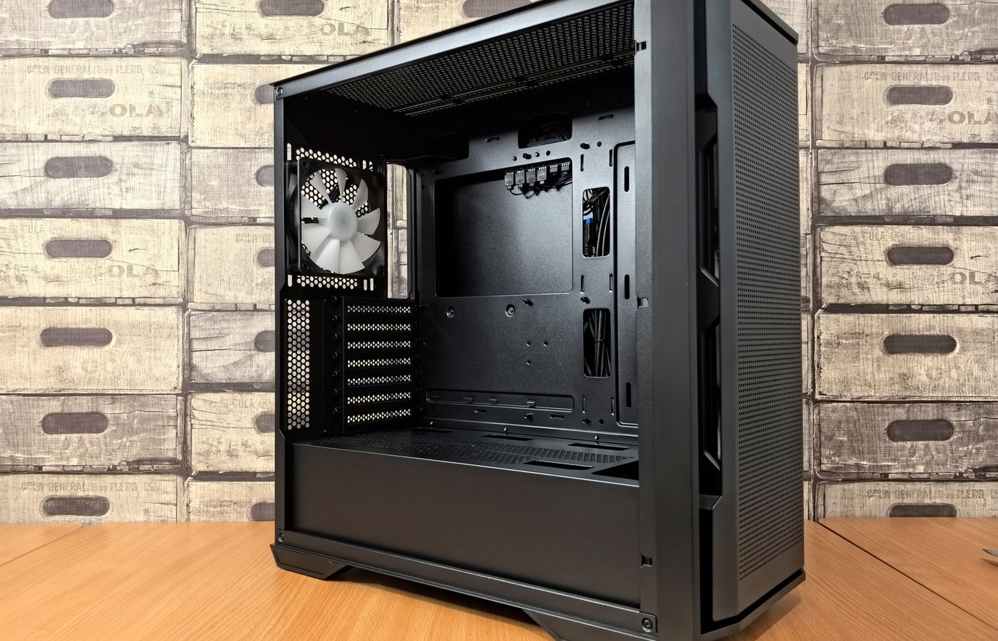 Open computer case with mounted fan, showcasing modern PC design and interior space.