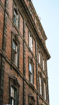 An urban view of a historic brick building showcasing its vintage architectural details.