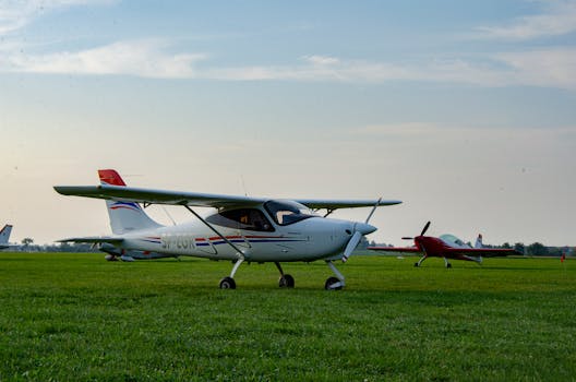 A small propeller airplane parked on a grass airfield, ready for flight during the day.