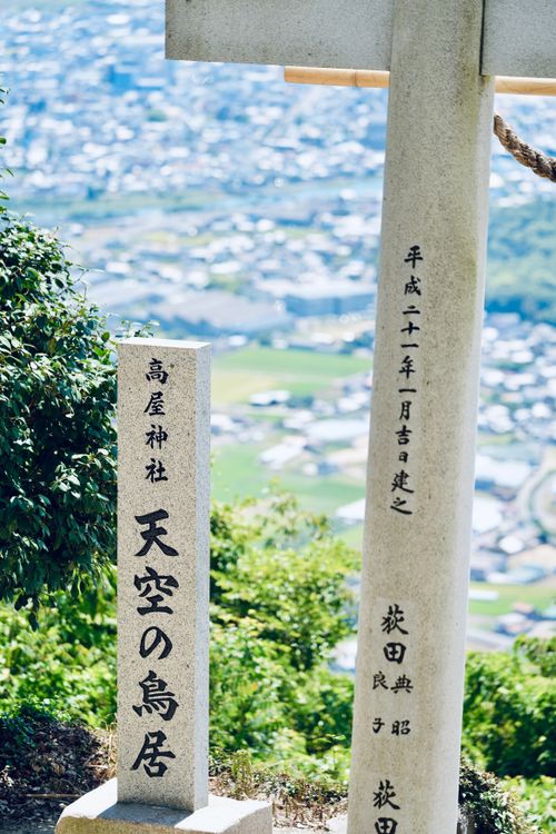Free A traditional Japanese stone Torii gate overlooking a serene landscape. Stock Photo