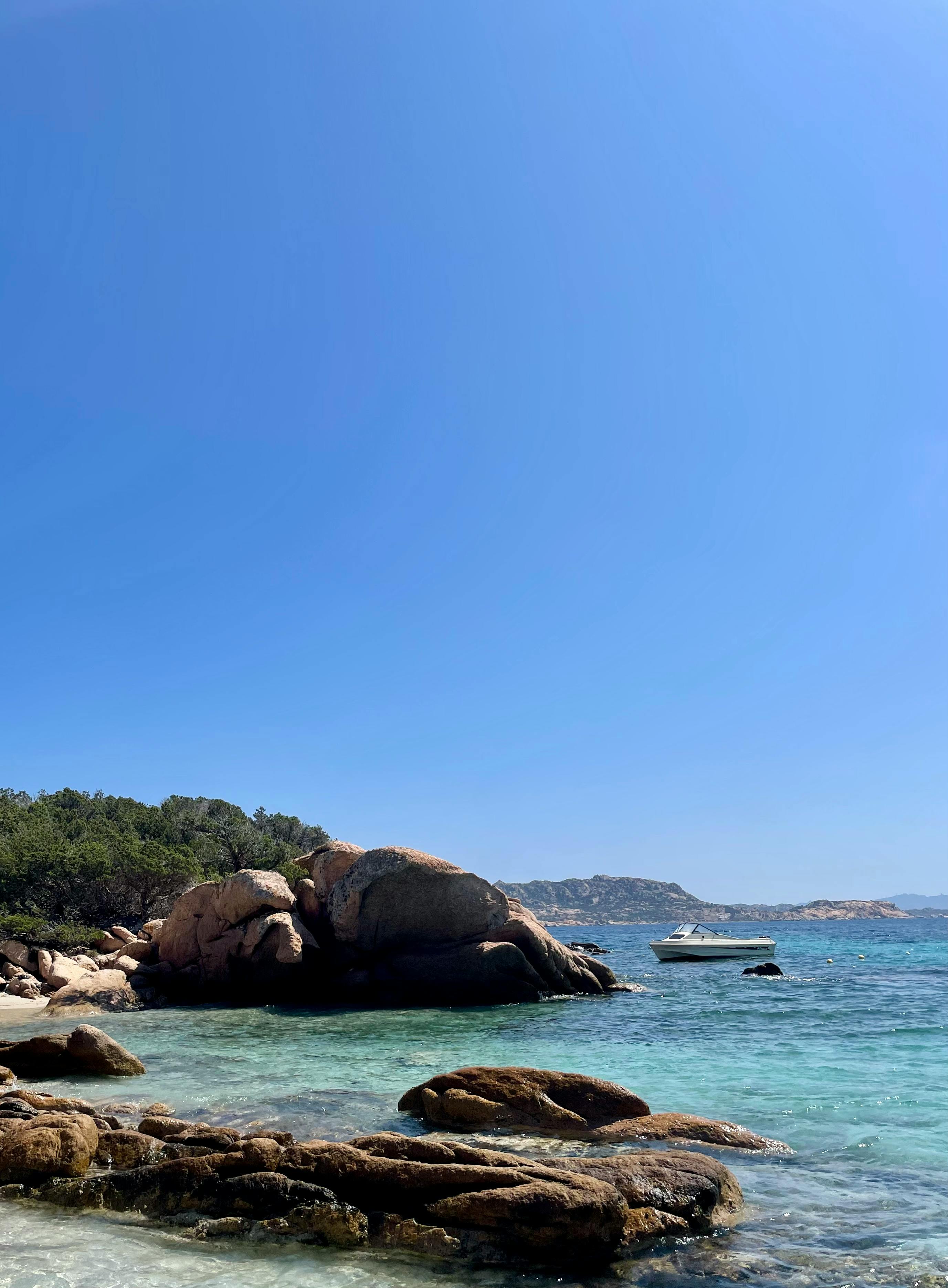 a boat is anchored in the water near some rocks