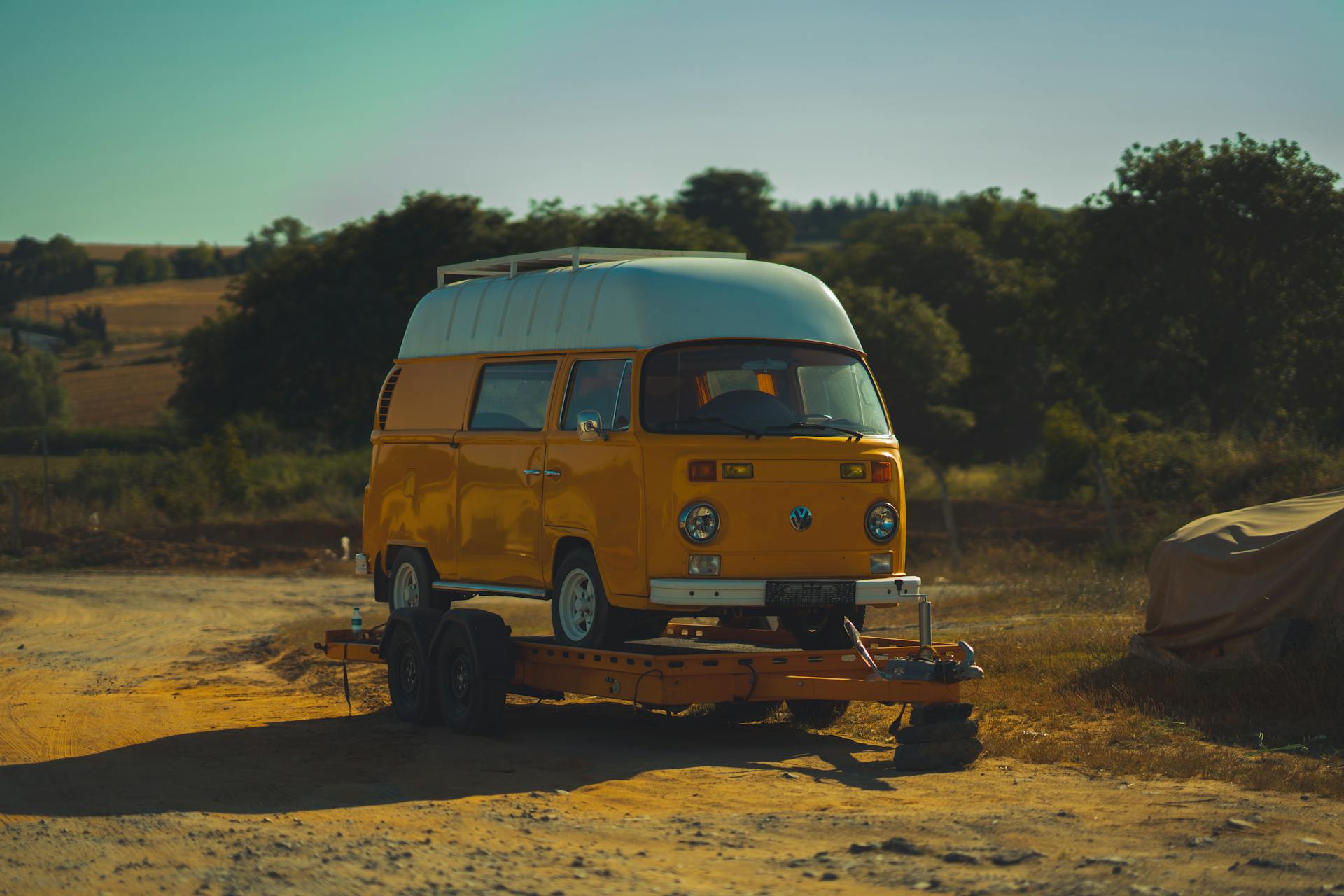 A yellow van is parked on a trailer