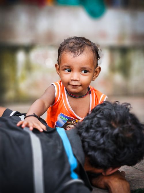 Free A cheerful baby interacts with his lying father, showcasing a joyful familial connection. Stock Photo
