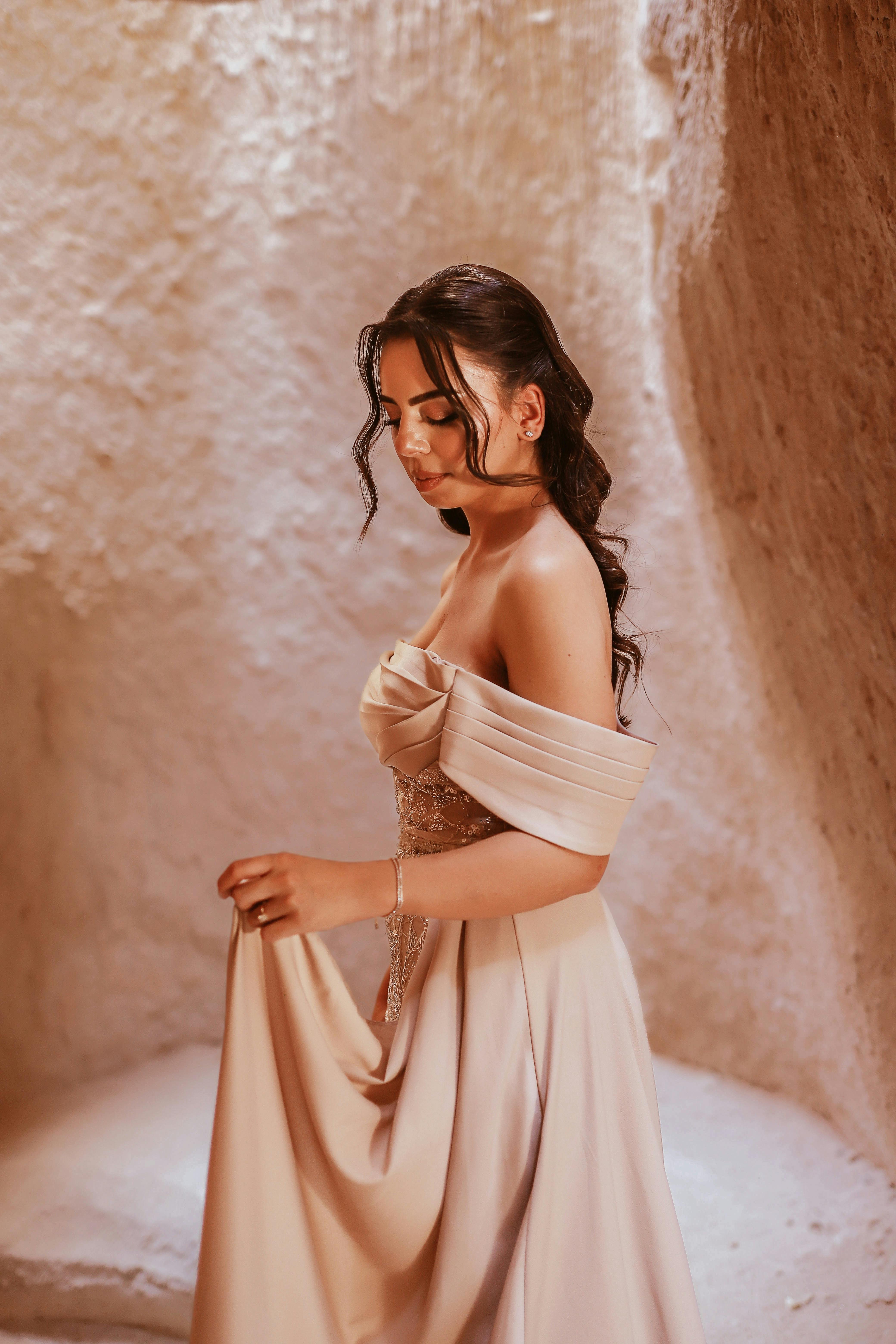 a woman in a long dress posing in a cave