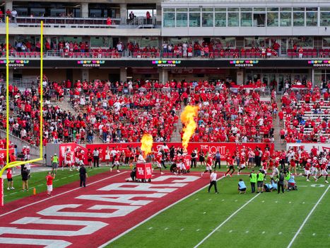 Houston college football match with vibrant crowd and fire effects. Captures the sports spirit.